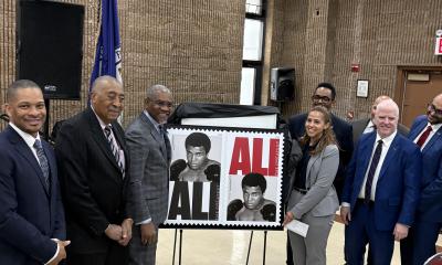 group of people with a stamp honoring Muhammad Ali